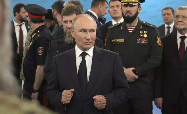 Russian President Vladimir Putin, centre, accompanied by Head of the Chechen Republic Ramzan Kadyrov, centre left, Prime Minister of the Chechen Republic Magomed Daudov, and Presidential Envoy to the North Caucasian Federal District Yury Chaika, right, talks to servicemen during his visit to the Special Forces University in Gudermes, Chechen Republic, Russia, Tuesday, Aug. 20, 2024. (Alexei Danichev, Sputnik, Kremlin Pool Photo via AP)