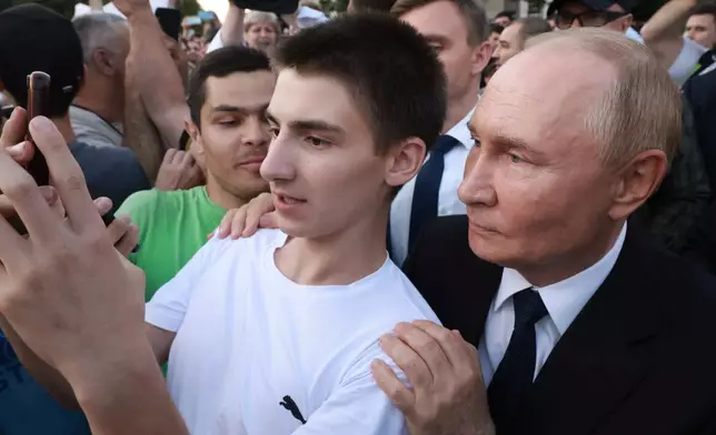 A young man takes a selfie with Russian President Vladimir Putin in Vladikavkaz, Republic of North Ossetia-Alania, Russia, Tuesday, Aug. 20, 2024. (Vyacheslav Prokofyev, Sputnik, Kremlin Pool Photo via AP)