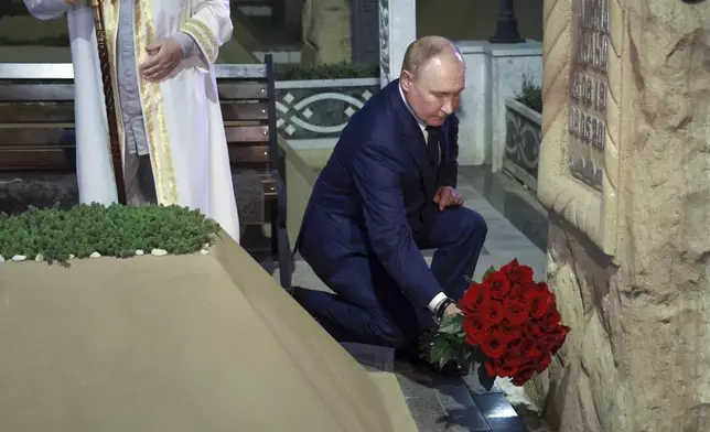 Russian President Vladimir Putin places flowers at the grave of the first president of Chechnya Akhmat-Khadzhi Kadyrov in the village of Akhmat-Yurt, Chechen Republic, Russia, Tuesday, Aug. 20, 2024. (Vyacheslav Prokofyev, Sputnik, Kremlin Pool Photo via AP)