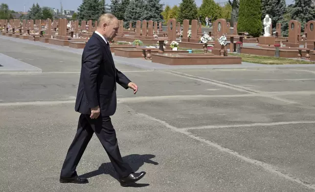 Russian President Vladimir Putin visits the City Of Angels memorial cemetery where victims of 2004 school siege are buried, in Beslan, the Republic of North Ossetia-Alania, Russia, Tuesday, Aug. 20, 2024. (Vladimir Astapkovich, Sputnik, Kremlin Pool Photo via AP)