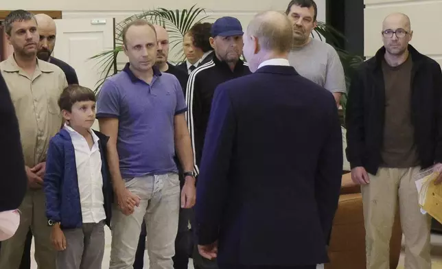 Russian President Vladimir Putin, front, greets released Russian prisoners and relatives at the government terminal of the Vnukovo airport in Moscow, Russia, Aug. 1, 2024. (Gavriil Grigorov, Sputnik, Kremlin Pool Photo via AP)