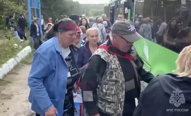 In this image made from video provided by Russian Emergency Situations Ministry press service, people board a bus during evacuation from a fighting between Russian and Ukrainian forces in Belovsky district, Kursk region, Russia, Monday, Aug. 12, 2024. (Ministry of Emergency Situations press service via AP)