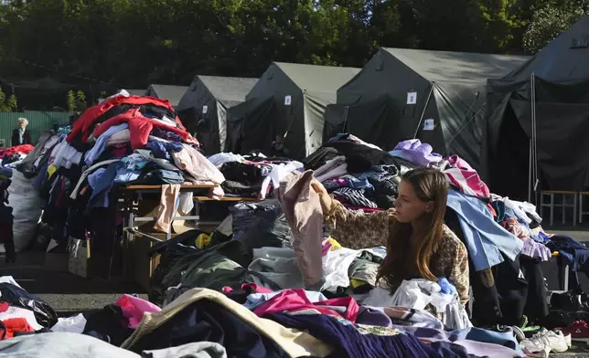 A woman evacuated from a fighting between Russian and Ukrainian forces in Kursk region chooses clothes at a temporary residence center in Kursk, Russia, Monday, Aug. 12, 2024. (AP Photo)