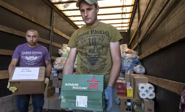 Volunteers unload humanitarian aid to people evacuated from a fighting between Russian and Ukrainian forces in Kursk region, at a temporary residence center in Kursk, Russia, Sunday, Aug. 11, 2024. (AP Photo)