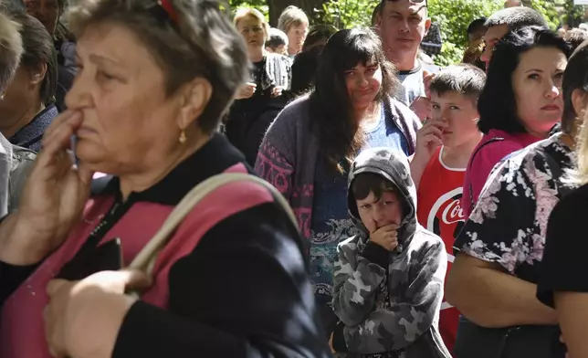 People evacuated from fighting between Russian and Ukrainian forces queue to receive humanitarian aid at a distribution center in Kursk, Russia, Monday, Aug. 12, 2024. (AP Photo)