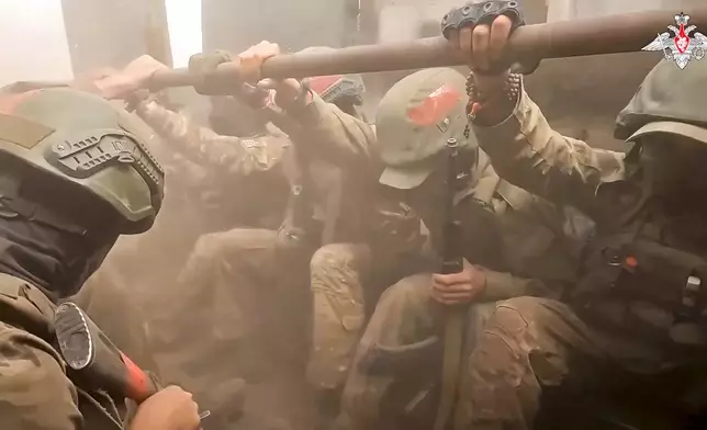 On this photo taken from video released by the Russian Defense Ministry on Monday, Aug. 26, 2024, A Russian assault unit prepare to leave an armoured personal carrier in the direction of Konstantinovka in Ukraine. (Russian Defense Ministry Press Service via AP)