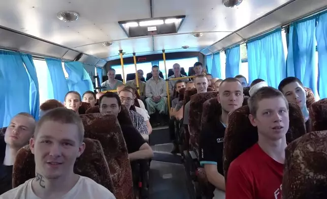 In this photo taken from video released by Russian Defense Ministry press service on Saturday, Aug. 24, 2024, Russian servicemen ride a bus after a prisoners exchange at an undisclosed location. (Russian Defense Ministry Press Service via AP)