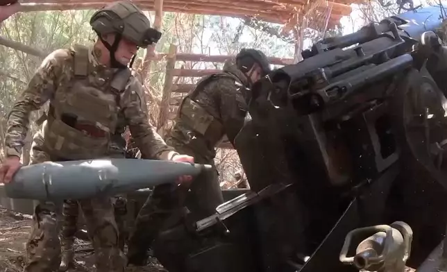 In this photo taken from video released by the Russian Defense Ministry on Tuesday, Aug. 20, 2024, Russian soldiers fire Giatsint-B gun towards Ukrainian positions at an undisclosed location in Kherson region in Ukraine. (Russian Defense Ministry Press Service photo via AP)