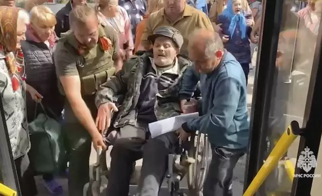 In this image made from video provided by Russian Emergency Situations Ministry press service, people board a bus during evacuation from a fighting between Russian and Ukrainian forces in Belovsky district, Kursk region, Russia, Monday, Aug. 12, 2024. (Ministry of Emergency Situations press service via AP)