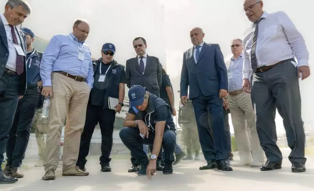 In this photo released by Rosatom State Atomic Energy Corporation, International Atomic Energy Agency chief Rafael Grossi, center, looks at a damage after shelling by Ukraine forces while inspecting the Kursk Nuclear Power Plant (KNPP) outside the town of Kurchatov, in the Kursk region, Russia, Tuesday, Aug. 27, 2024. (Rosatom State Atomic Energy Corporation via AP)