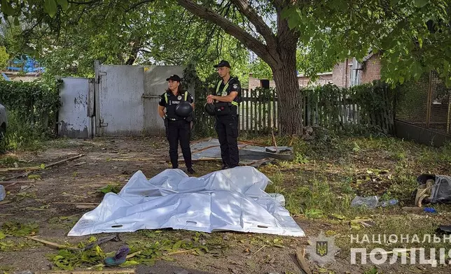 In this photo provided by the National Police of Ukraine on Tuesday, August 27, 2024, Police offices stand next to bodies covered with plastic bags after Russian airstrike in Zaporizhzhia, Ukraine. (National Police of Ukraine via AP)