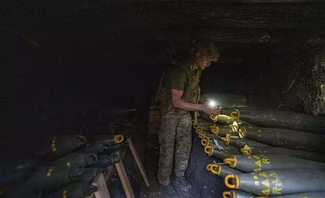 Ukrainian serviceman Oleh of 148th separate artillery brigade of the Air Assault Forces prepares 155mm artillery shells before firing towards Russian positions at the frontline in Donetsk region, Ukraine, Wednesday, August 21, 2024. (AP Photo/Evgeniy Maloletka)