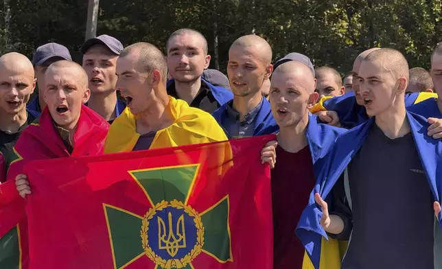 In this photo provided by the Ukrainian Presidential Press Office on Saturday, Aug. 24, 2024, a Ukrainian prisoner of war holds the National Guard flag after a prisoners exchange at an undisclosed location in Ukraine. (Ukrainian Presidential Press Office via AP)