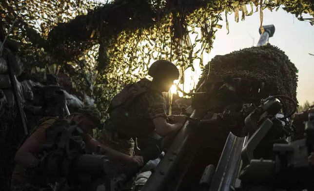 Ukrainian servicemen of 148th separate artillery brigade of the Air Assault Forces prepare their M777 howitzer before firing towards Russian positions at the frontline in Donetsk region, Ukraine, Wednesday, August 21, 2024. (AP Photo/Evgeniy Maloletka)