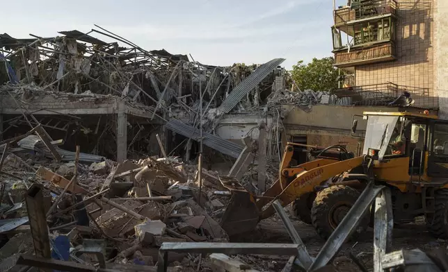 A tractor clears the rubble after a Russian strike on the Sapphire hotel in Kramatorsk, Donetsk region, Ukraine, on Sunday, Aug. 25, 2024. (AP Photo/Evgeniy Maloletka)