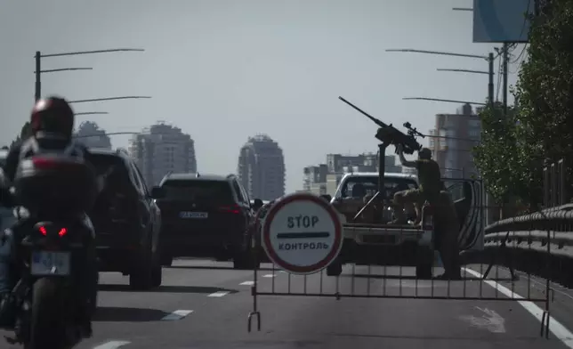 Ukrainian soldiers guard the sky with a machine-gun on a city road during one of Russian most massive missile and drone attack against Ukraine's energy objects in Kyiv, Ukraine, Monday, Aug. 26, 2024. (AP Photo/Efrem Lukatsky)