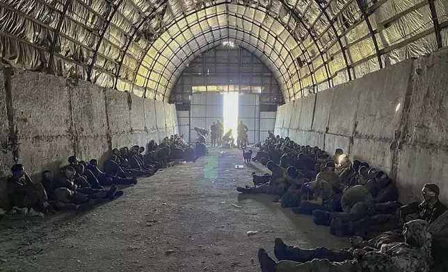 In this photo provided by the Ukrainian Security Service Press Office, over 100 Russian prisoners of war captured by a Security Service special unit during one military action are seen in a shelter in Kursk region, Russia, Wednesday, Aug. 14, 2024. (Ukrainian Security Service Press Office via AP)