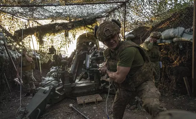 A Ukrainian serviceman Oleh of 148th separate artillery brigade of the Air Assault Forces fires towards Russian positions by a M777 howitzer at the frontline in Donetsk region, Ukraine, Wednesday, August 21, 2024. (AP Photo/Evgeniy Maloletka)