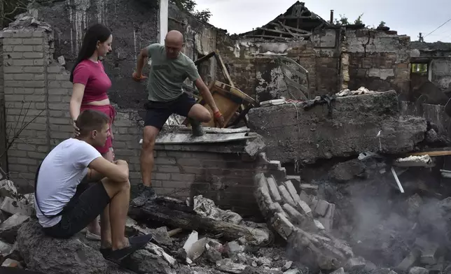 A couple sit in front of their house destroyed by a Russian strike in Zaporizhzhia, Ukraine, Tuesday, Aug. 27, 2024. (AP Photo/Andriy Andriyenko)