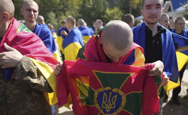 In this photo provided by the Ukrainian Presidential Press Office on Saturday, Aug. 24, 2024, a Ukrainian prisoner of war holds the National Guard flag after a prisoners exchange at an undisclosed location in Ukraine. (Ukrainian Presidential Press Office via AP)