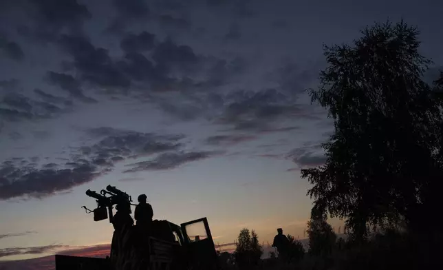 A volunteer for an air-defense unit prepares a machine gun near Bucha, Kyiv region, Ukraine, Aug. 9, 2024. (AP Photo/Evgeniy Maloletka)