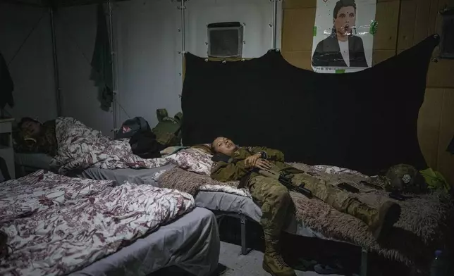 A volunteer for an air-defense unit rests during her shift near Bucha, Kyiv region, Ukraine, Aug. 8, 2024. (AP Photo/Evgeniy Maloletka)