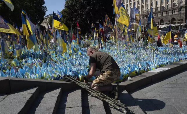 A veteran pays his respect at a makeshift memorial for fallen Ukrainian soldiers during the Ukrainian Independence Day on Independence Square in Kyiv, Ukraine, Saturday, Aug. 24, 2024. (AP Photo/Efrem Lukatsky)