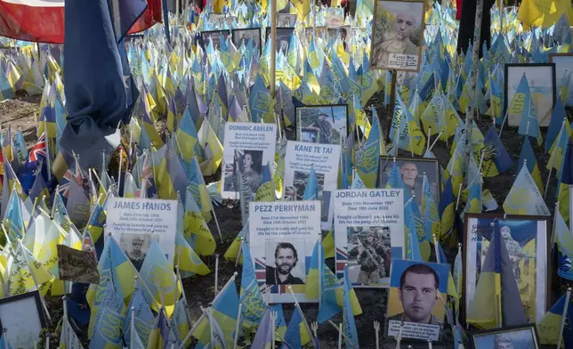 Flags with names of killed international volunteers are carried during Ukrainian Independence Day on Independence Square in Kyiv, Ukraine, Saturday, Aug. 24, 2024. (AP Photo/Efrem Lukatsky)