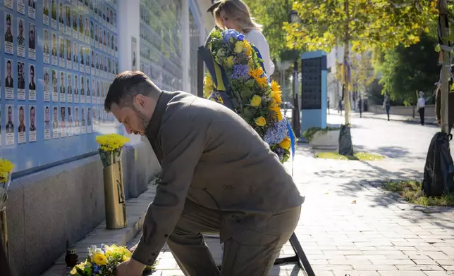 In this photo provided by the Ukrainian Presidential Press Office, Ukrainian President Volodymyr Zelenskyy lays flowers at the Memorial Wall of Fallen Defenders of Ukraine in Russian-Ukrainian War during celebration of the Ukrainian Independence Day in Kyiv, Ukraine, Saturday, Aug. 24, 2024. (Ukrainian Presidential Press Office via AP)