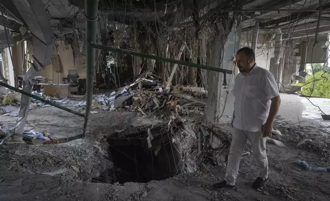 Alya Gali, a Gaza Strip-born doctor, looks at debris two weeks after a missile killed nine as it hit a private clinic where he has worked for most of his professional life in Kyiv, Ukraine, Monday, July 22, 2024. Russia’s full-scale invasion of Ukraine in 2022 catapulted Gali’s life into the chaos of constant air raids and missile attacks. Israel’s war on Hamas turned his hometown into a hellscape, uprooting his family and killing two of his relatives. (AP Photo/Efrem Lukatsky)