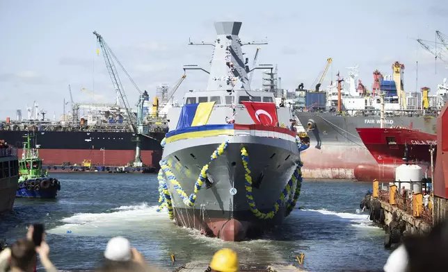 In this photo provided by the Ukrainian Presidential Press Office, people react during the launching ceremony of the Ukrainian Navy's Ada class corvette "Hetman Ivan Vyhovskyi" in Istanbul, Turkey, Thursday, Aug. 1, 2024. This vessel was constructed for the Ukrainian Navy at a shipyard in Turkey. (Ukrainian Presidential Press Office via AP)