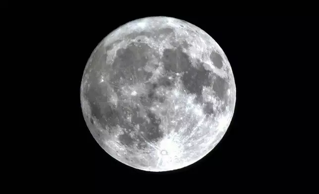 A nearly full supermoon rises in the sky after rain in Beijing, Monday, Aug. 19, 2024. (AP Photo/Andy Wong)