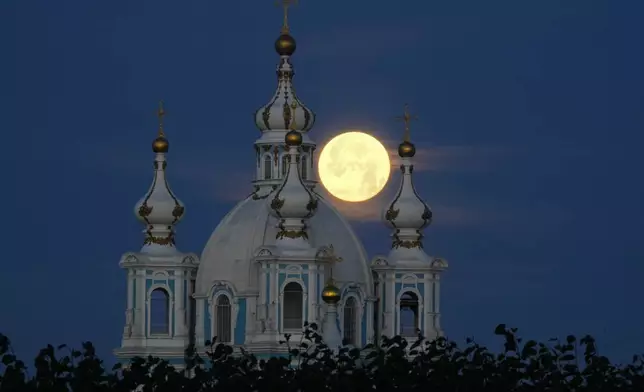 The supermoon is seen over the Smolny Cathedral in St. Petersburg, Russia, Tuesday, Aug. 20, 2024. (AP Photo/Dmitri Lovetsky)