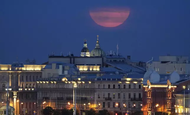 The super moon rises in the clouds over St. Petersburg, Russia, Monday, Aug. 19, 2024. (AP Photo/Dmitri Lovetsky)