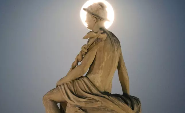 A statue of Mercury and supermoon are seen at Kastellet in Copenhagen Monday, Aug. 19, 2024. (Thomas Traasdahl/Ritzau Scanpix via AP)