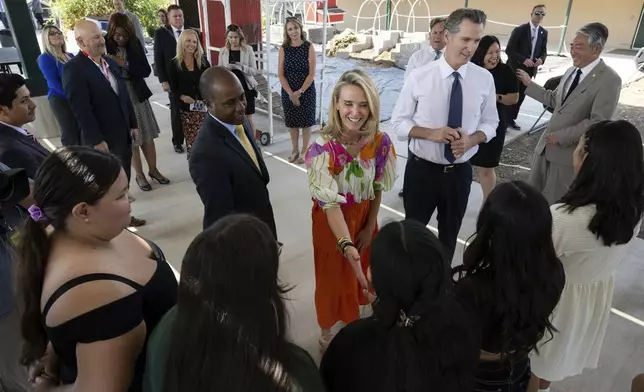 FILE - California First Partner Jennifer Siebel Newsom, center, greets a student while she stands with state Superintendent of Public Instruction Tony Thurmond and Gov. (Paul Kitagaki Jr./The Sacramento Bee via AP, Pool, File)