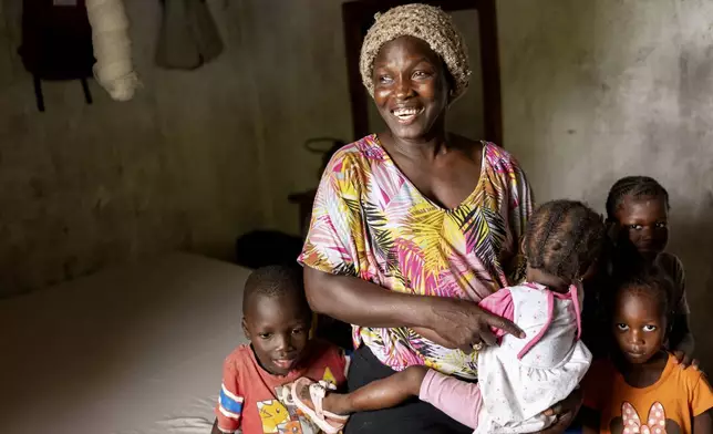 Coach Isabelle Sambou, 43 years old, two-time Olympian and nine-time African wrestling champion, plays with children at her house in Mlomp, southern Senegal, Wednesday, July 10, 2024. (AP Photo/Sylvain Cherkaoui)