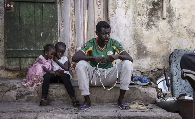 Cheikh Gueye, a 46-year-old fisherman who recently tried to migrate to Europe, prays at his family house in Thiaroye-Sur-Mer, Senegal, Friday, Aug. 23, 2024. Migrants leave on artisanal fishing boats known as pirogues and navigate for several days against strong winds and Atlantic currents. While thousands have survived the risky journey, many die or disappear along the way with remains sometimes washing up on the other side of the Atlantic. (AP Photo/Annika Hammerschlag)