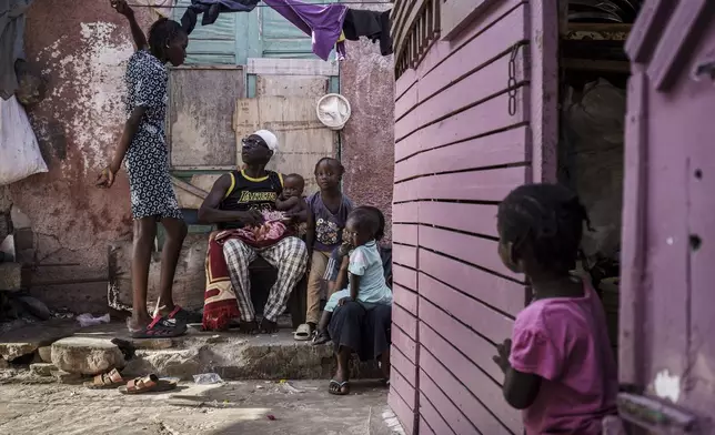 Salamba Ndeye, left, a 28-year-old who tried to migrate to Europe twice, speaks with family members in Thiaroye-Sur-Mer, Senegal, Friday, Aug. 23, 2024. Salamba is one of thousands of young Senegalese who try to flee poverty and the lack of job opportunities in the West African country each year to head to Spain. More than 22,300 people have landed on the Canary Islands from January to mid-August this year. (AP Photo/Annika Hammerschlag)