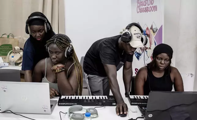 Aminata "Myamy TheAyGirl" Thiam, 31 years-old, left, and Alioune Faye, 29 years -old, right, instruct students at a beat making class for women in Dakar, Senegal, Wednesday, Aug. 14, 2024. Aminata Thiam is Senegal's first female beatmaker. (AP Photo/Annika Hammerschlag)