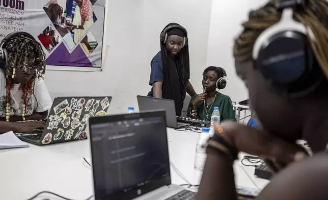 Aminata "Myamy TheAyGirl" Thiam, 31years - Old, center, instructs a student 30 years old Julia Sall, at a beat making class for women in Dakar, Senegal, Wednesday, Aug. 14, 2024. Aminata Thiam is Senegal's first female beatmaker. (AP Photo/Annika Hammerschlag)