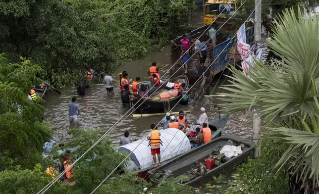 Volunteers carry relief material to the flooded areas in Feni, in south-eastern Bangladesh, Friday, Aug. 23, 2024. (AP Photo/Fatima Tuj Johora)