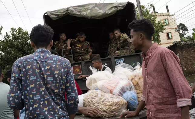 Bangladesh army soldiers distribute relief material to the flooded areas in Feni, in south-eastern Bangladesh, Friday, Aug. 23, 2024. (AP Photo/Fatima Tuj Johora)