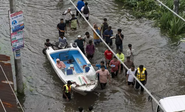 People bring a speed boat to rescue stranded residents in a flooded area of Feni, a coastal district in southeast Bangladesh, Friday, Aug. 23, 2024. (AP Photo/Fatima Tuj Johora)