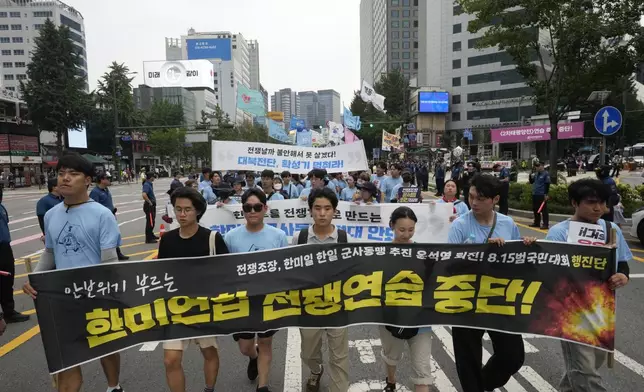 South Korean protesters march during a rally opposing the joint military exercises between the U.S. and South Korea in Seoul, South Korea, Saturday, Aug. 10, 2024. The banner reads "Stop the military exercises between the U.S. and South Korea."(AP Photo/Ahn Young-joon)