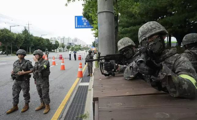 South Korean army soldiers aim their machine guns as they control traffic during a civil defense drill as a part of the Ulchi Freedom Shield military exercise between the U.S. and South Korea in Seoul, South Korea, Thursday, Aug. 22, 2024. (AP Photo/Ahn Young-joon)