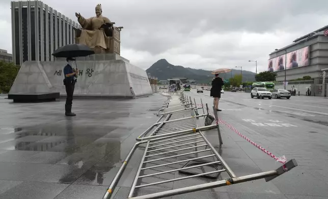 Fences are laid down by government in preparation for an approaching tropical depression which was weakend from Tropical Storm Jongdari, on Gwanghwamun Square in Seoul, South Korea, Wednesday, Aug. 21, 2024. (AP Photo/Ahn Young-joon)