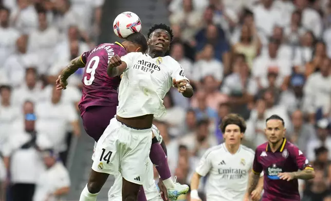 Real Madrid's Aurelien Tchouameni, centre, and Valladolid's Marcos Andre challenge for the ball during the Spanish La Liga soccer match between Real Madrid and Valladolid at the Santiago Bernabeu stadium in Madrid, Spain, Sunday, Aug. 25, 2024. (AP Photo/Manu Fernandez)