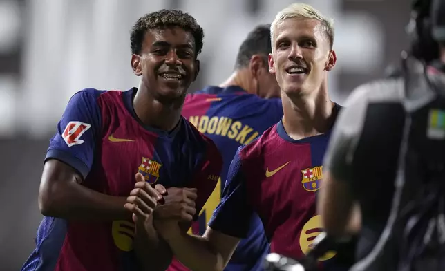 Barcelona's Dani Olmo, right, celebrates with Barcelona's Lamine Yamal after scoring his side's second goal during the Spanish La Liga soccer match between Rayo Vallecano and Barcelona at the Vallecas stadium in Madrid, Spain, Tuesday, Aug. 27, 2024. (AP Photo/Manu Fernandez)