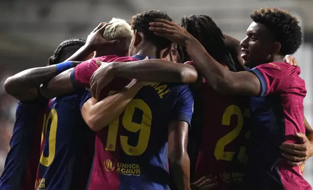 Barcelona players celebrate after Barcelona's Dani Olmo scored his side's second goal during the Spanish La Liga soccer match between Rayo Vallecano and Barcelona at the Vallecas stadium in Madrid, Spain, Tuesday, Aug. 27, 2024. (AP Photo/Manu Fernandez)